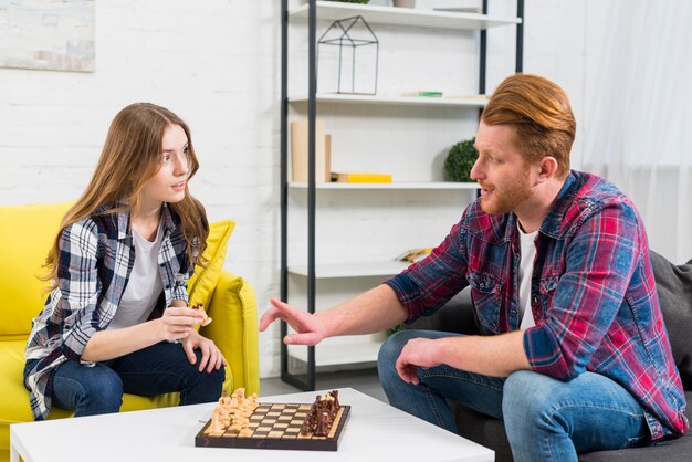 Junge Paare, die zu Hause Schachspiel spielen