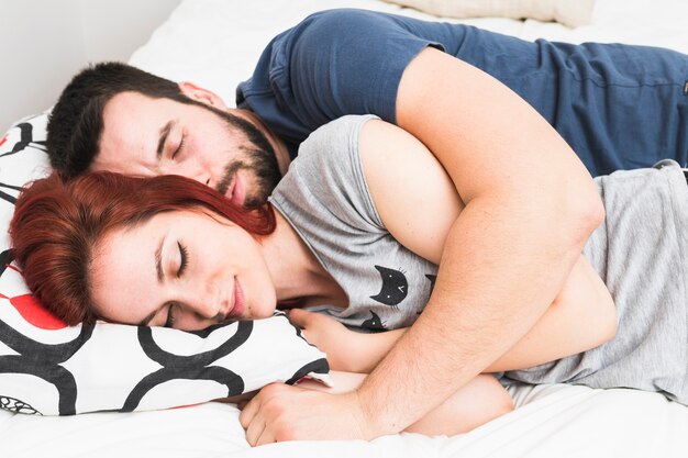 Junge Paare, die zusammen auf Bett schlafen