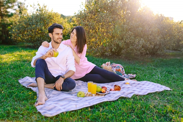 Junge Paare im Park, der draußen ein Picknick hat