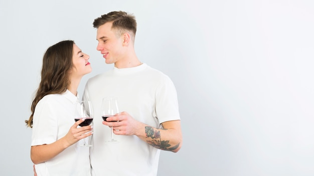 Junge Paare im weißen trinkenden Wein