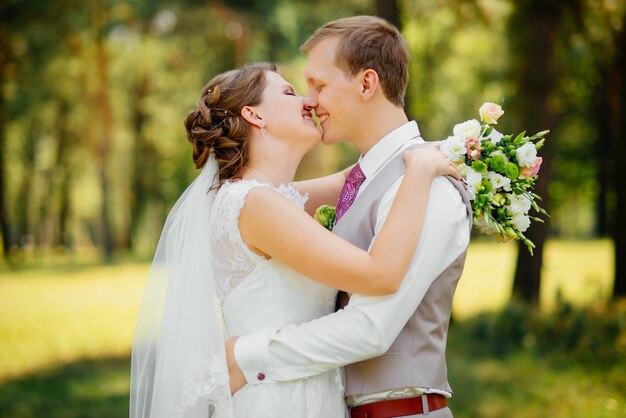 Junge Paare in der Liebe, im Bräutigam und in der Braut im Hochzeitskleid an der Natur. Hochzeit.