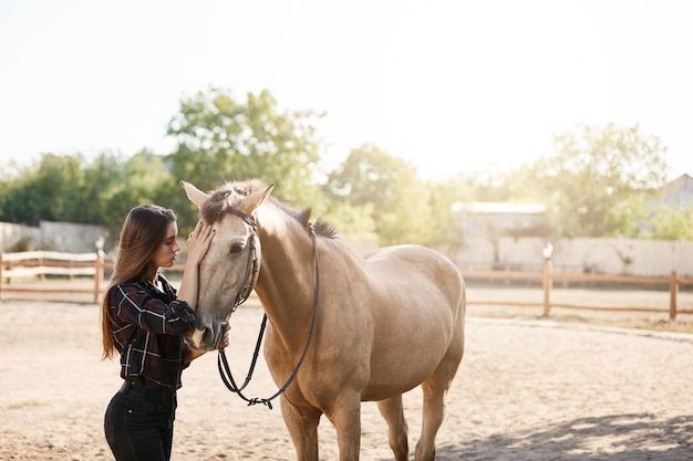 Junge Pferdebesitzerin, die mit einem Tier auf einem Bauernhof oder einer Ranch spazieren geht Freiheitskonzept