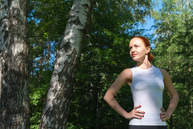 Kostenloses Foto junge rote frau steht im wald