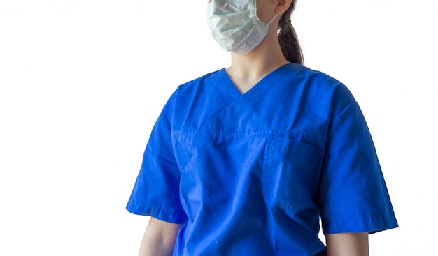 Junge Ärztin, die eine blaue medizinische Uniform und eine Maske trägt