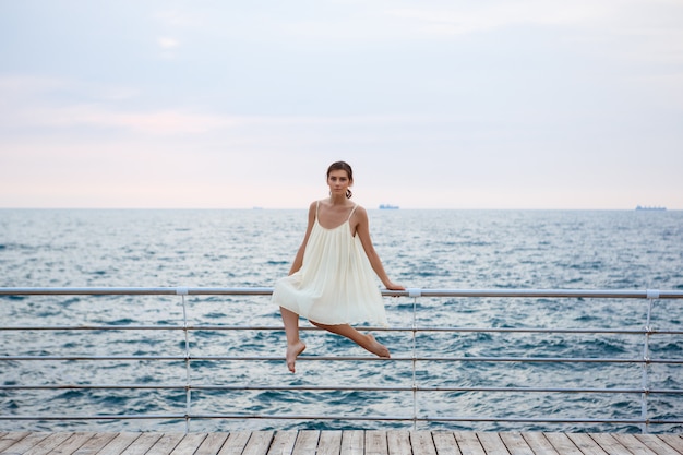 Junge schöne Ballerina, die draußen tanzt und posiert