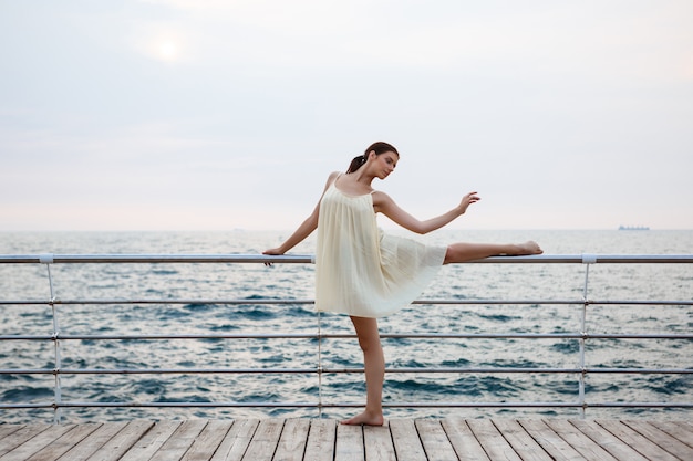 Junge schöne Ballerina, die draußen tanzt und posiert