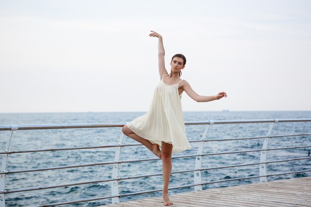 Junge schöne Ballerina, die draußen tanzt und posiert