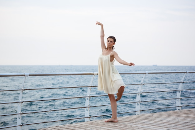 Junge schöne Ballerina, die draußen tanzt und posiert