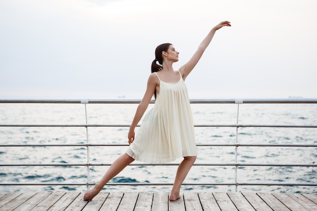 Junge schöne Ballerina, die draußen tanzt und posiert