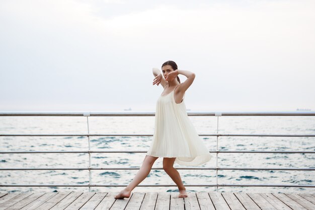 Junge schöne Ballerina, die draußen tanzt und posiert