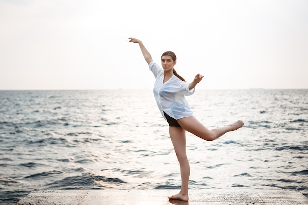 Junge schöne Ballerina, die draußen tanzt und posiert