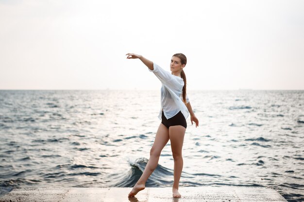 Junge schöne Ballerina, die draußen tanzt und posiert