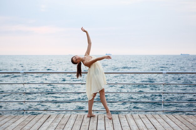 Junge schöne Ballerina, die draußen tanzt und posiert