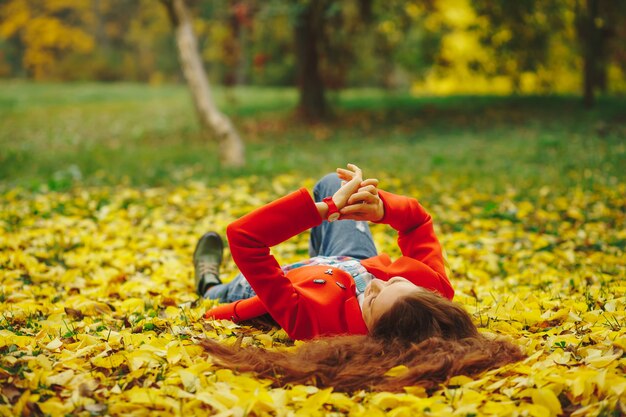 Junge schöne Dame umgab Herbstlaub