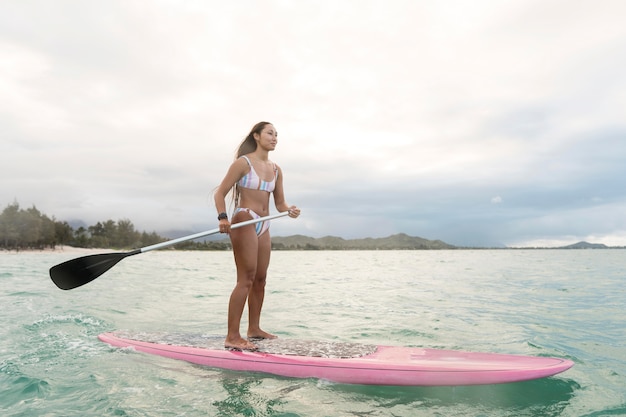 Junge schöne Frau, die in Hawaii surft