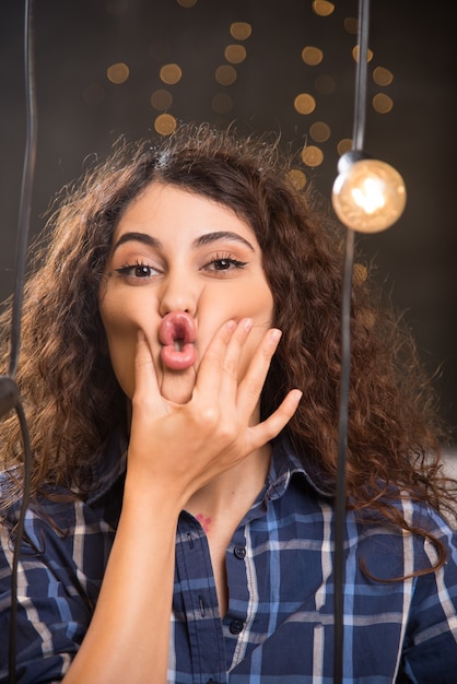 Junge schöne Frau, die Mund und Lippen als Reißverschluss mit den Fingern geschlossen hält