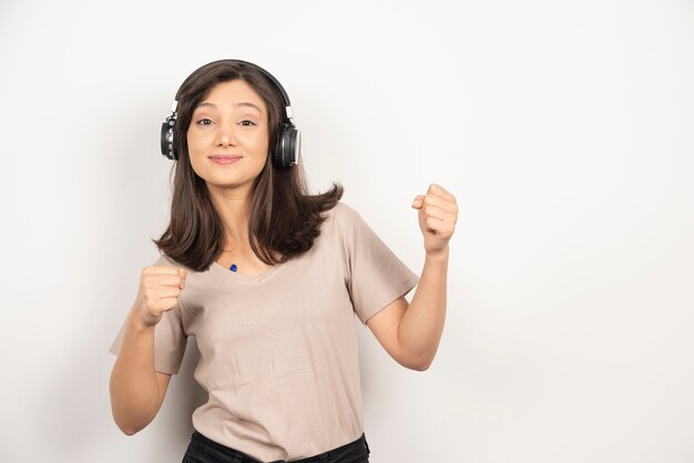 Junge schöne Frau, die Musik mit Kopfhörern hört.