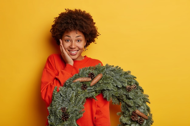 Junge schöne Frau, die Weihnachtsdekorationen hält