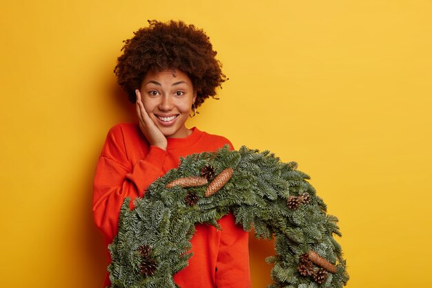 Junge schöne Frau, die Weihnachtsdekorationen hält