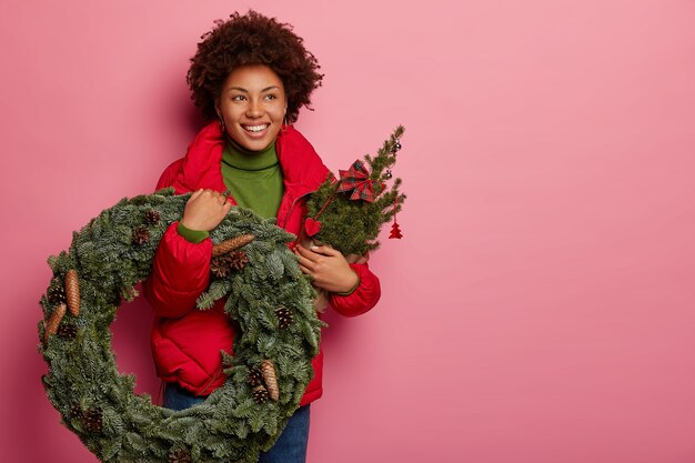 Junge schöne Frau, die Weihnachtsdekorationen hält