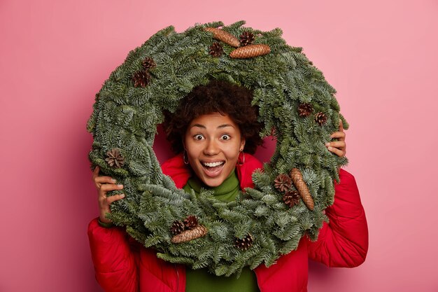 Junge schöne Frau, die Weihnachtsdekorationen hält