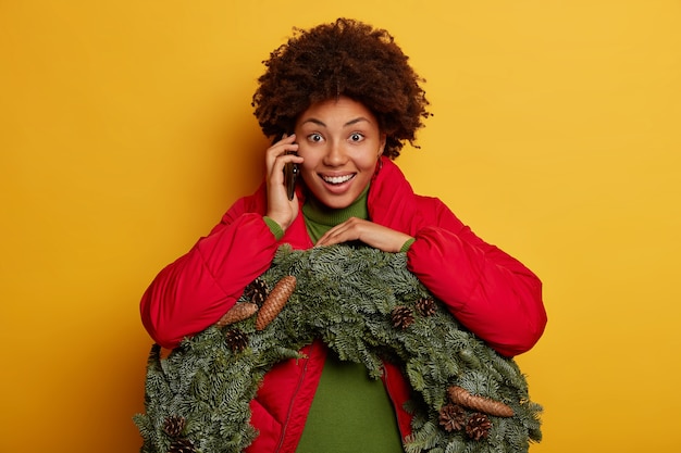 Junge schöne Frau, die Weihnachtsdekorationen hält