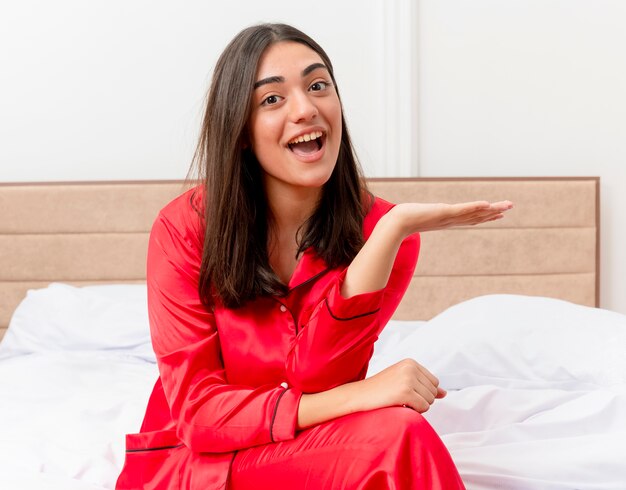 Junge schöne Frau im roten Schlafanzug, der im Bett entspannt