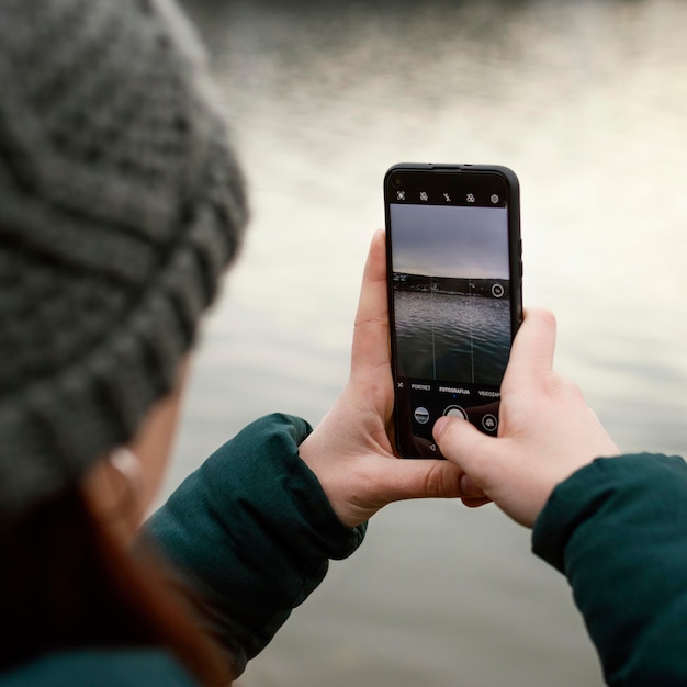 Junge schöne Frau in der Natur, die Fotos macht