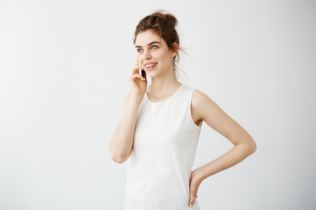 Junge schöne Frau mit Brötchen lächelnd am Telefon sprechen.