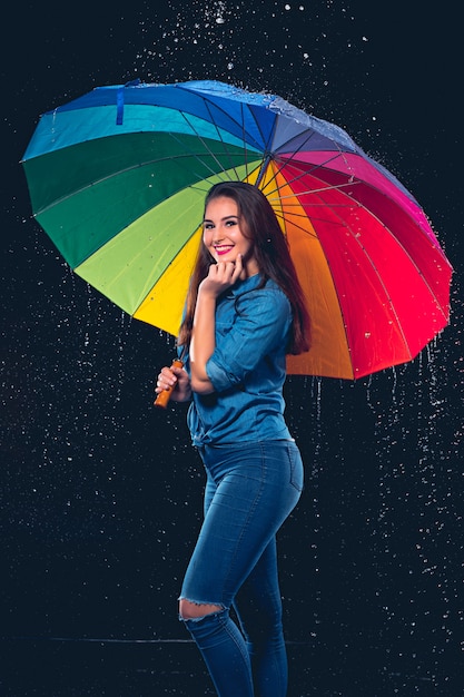 Junge schöne Frau mit einem Regenschirm.