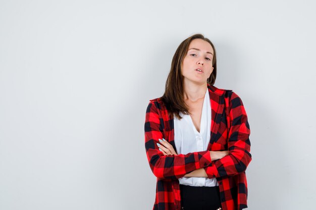 Junge schöne Frauen, die Arme in lässigem Outfit verschränkt und selbstbewusst aussehen, Vorderansicht.