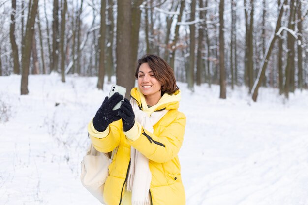 Junge schöne glückliche fröhliche Frau im Winterwald-Videoblog, macht ein Selfie-Foto