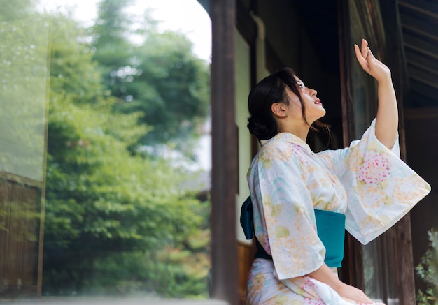 Junge schöne japanische frau, die einen traditionellen kimono trägt