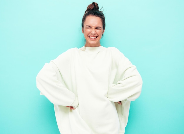 Junge schöne lächelnde Frau in trendiger Sommerkleidung sorglose Frau posiert in der Nähe der Wand im Studio Positives brünettes Modell, das Spaß hat Fröhlich und glücklich