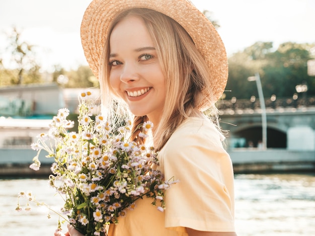 Junge schöne lächelnde Hippie-Frau im trendigen Sommerkleid