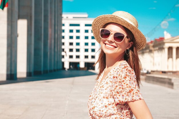 Junge schöne lächelnde Hipster-Frau in trendiger Sommerkleidung Sexy sorglose Frau, die bei Sonnenuntergang auf dem Straßenhintergrund posiert Positives Modell im Freien Fröhlich und glücklich mit Sonnenbrille