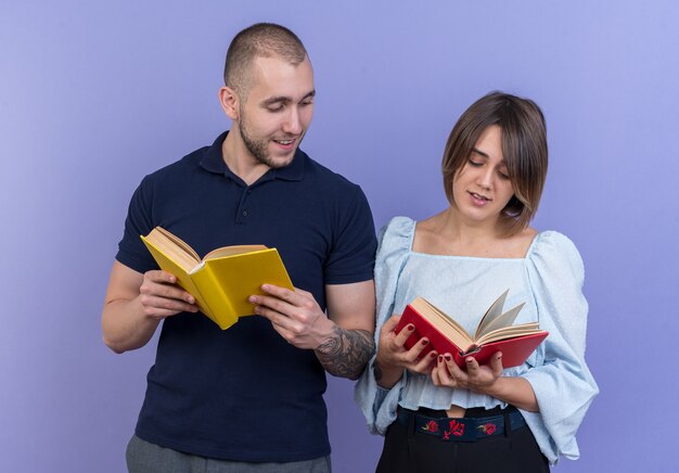 Junge schöne Paar Mann und Frau, die Bücher in den Händen halten glücklich und positiv lächelnd fröhlich stehend