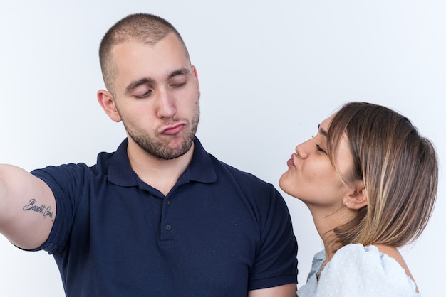 Junge schöne Paare, Mann und Frau, die sich glücklich in der Liebe ansehen, werden sich gegenseitig küssen