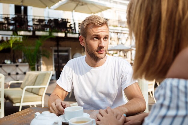 Junge schöne Paare streiten, sitzen im Café.