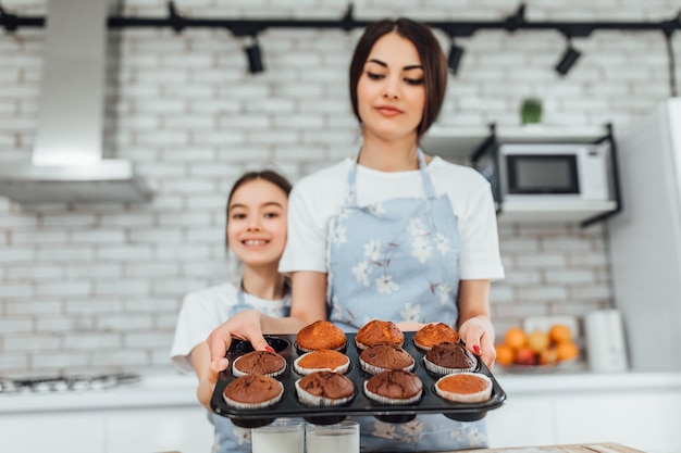 Kostenloses Foto junge schöne schwestern kochen cupcakes