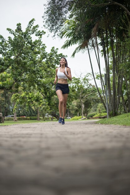 Junge schöne Sportfrau, die am Park läuft. Gesundheits- und Sportkonzept.