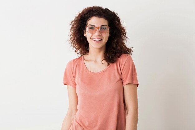 Junge schöne stilvolle Frau in Brille, lockiges Haar, aufrichtiges Lächeln, positive Emotion, glücklich, isoliert, rosa T-Shirt