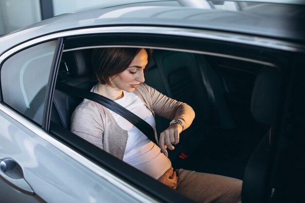 Junge schwangere Frau, die im Auto zum Krankenhaus fährt