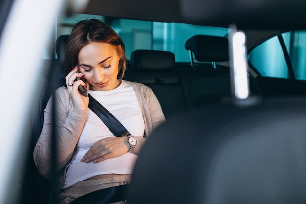 Junge schwangere Frau, die im Auto zum Krankenhaus fährt