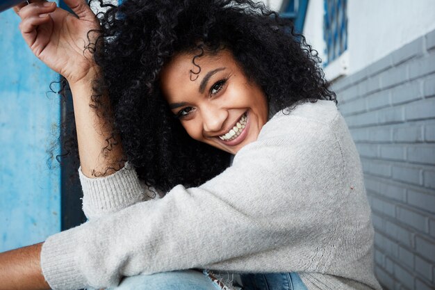 junge schwarze Frau mit Afro-Haaren, die lachen und genießen