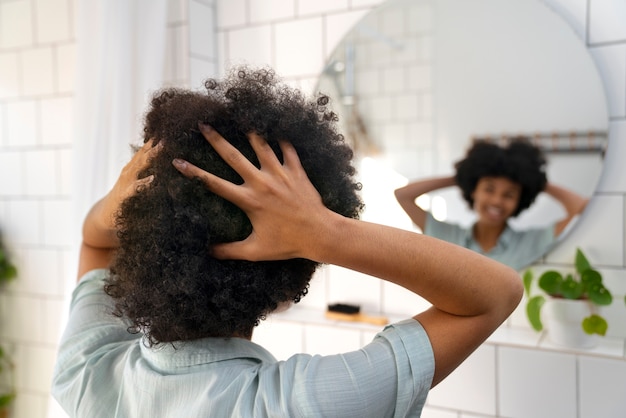 Junge schwarze Person, die sich um Afrohaar kümmert