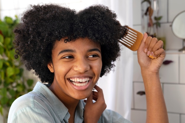 Junge schwarze Person, die sich um Afrohaar kümmert