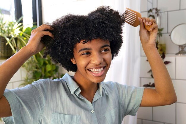 Junge schwarze Person, die sich um Afrohaar kümmert