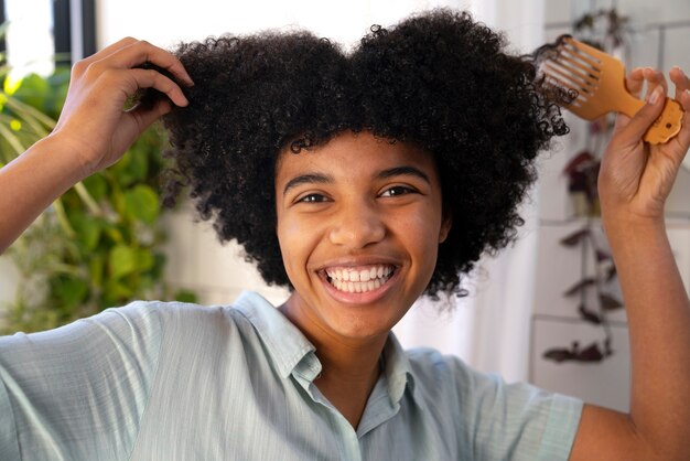 Junge schwarze Person, die sich um Afrohaar kümmert