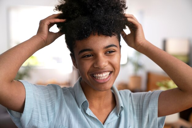 Junge schwarze Person, die sich um Afrohaar kümmert